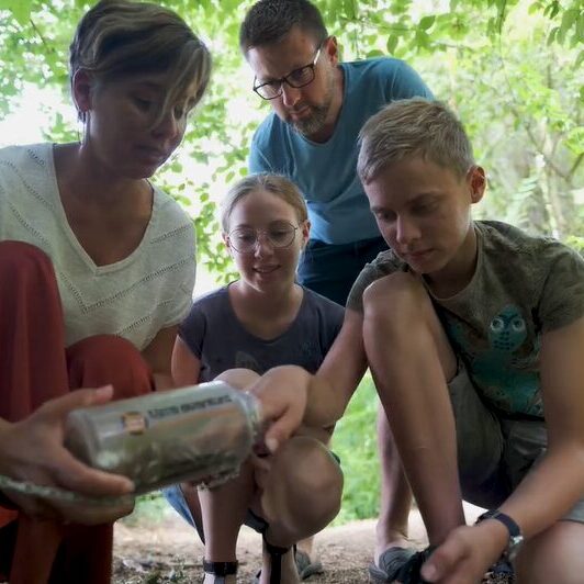 Famille découvrant une capsule lors d’une activité en pleine nature en Haut-Poitou
